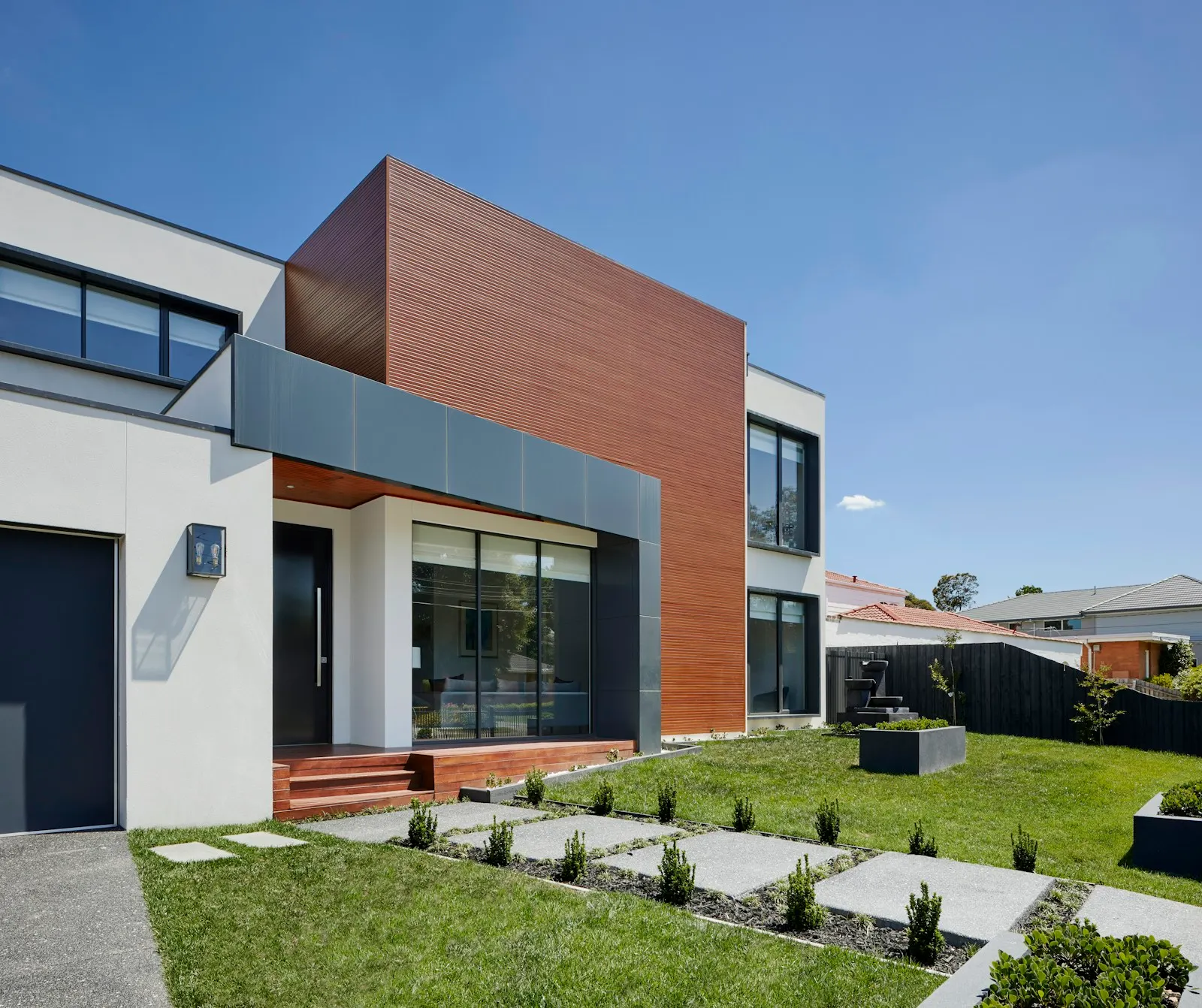 House exterior in warm evening light with landscaped courtyard