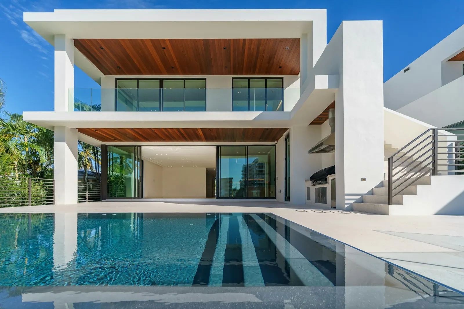 Modern villa glowing warmly at night beside a still pool